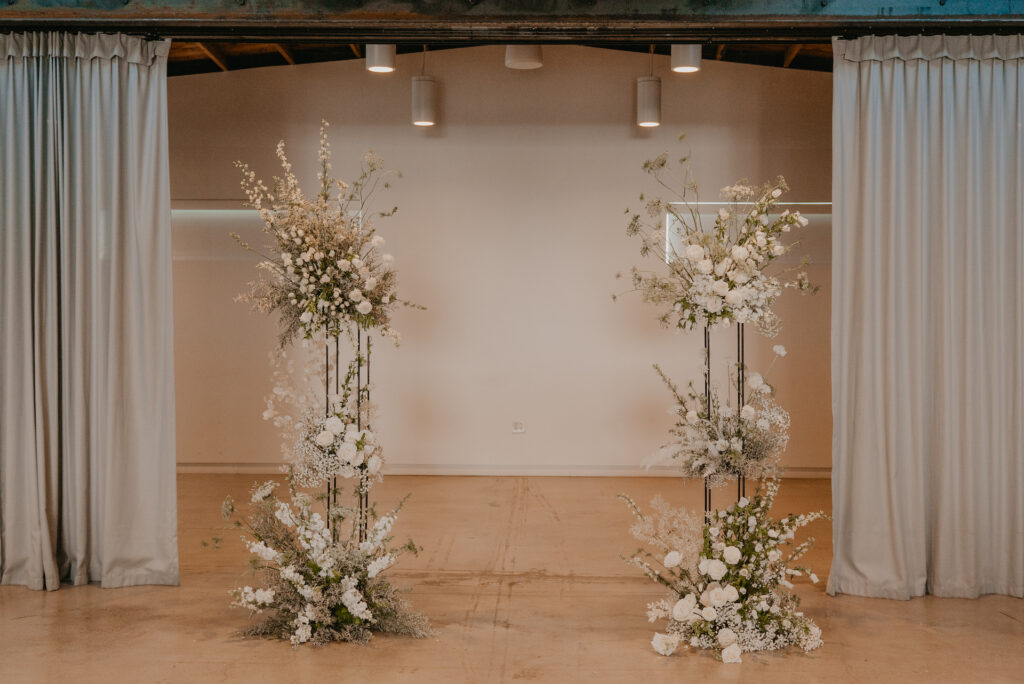 Flower pillars for wedding ceremony altar space of white flowers.