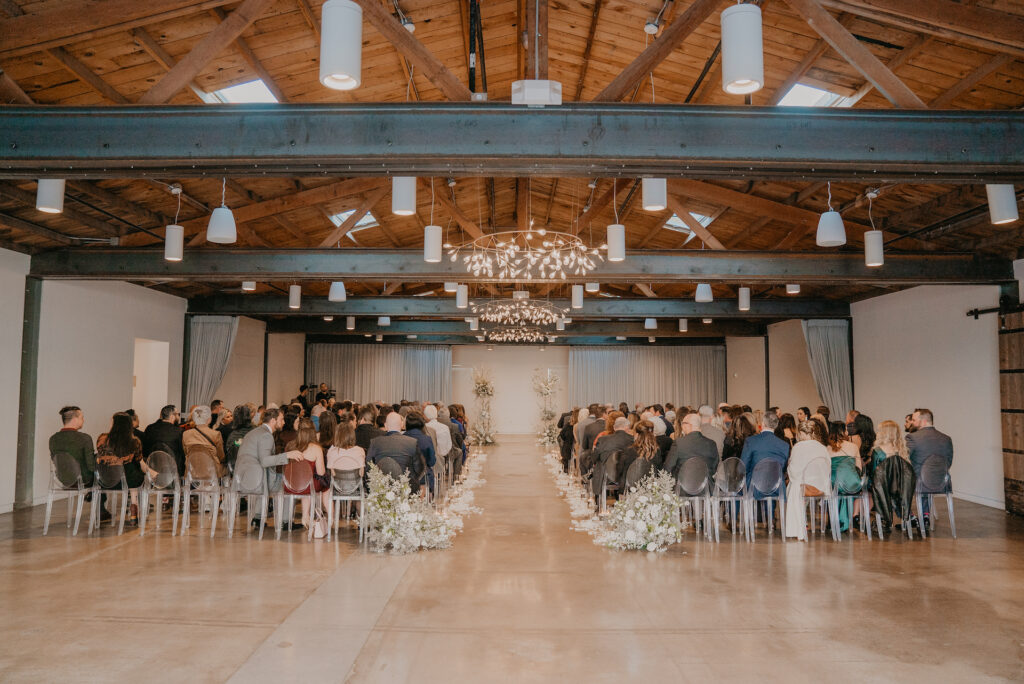 The Clayton House wedding ceremony with back of aisle ground floral, aisle rose pedals, and altar space floral columns.