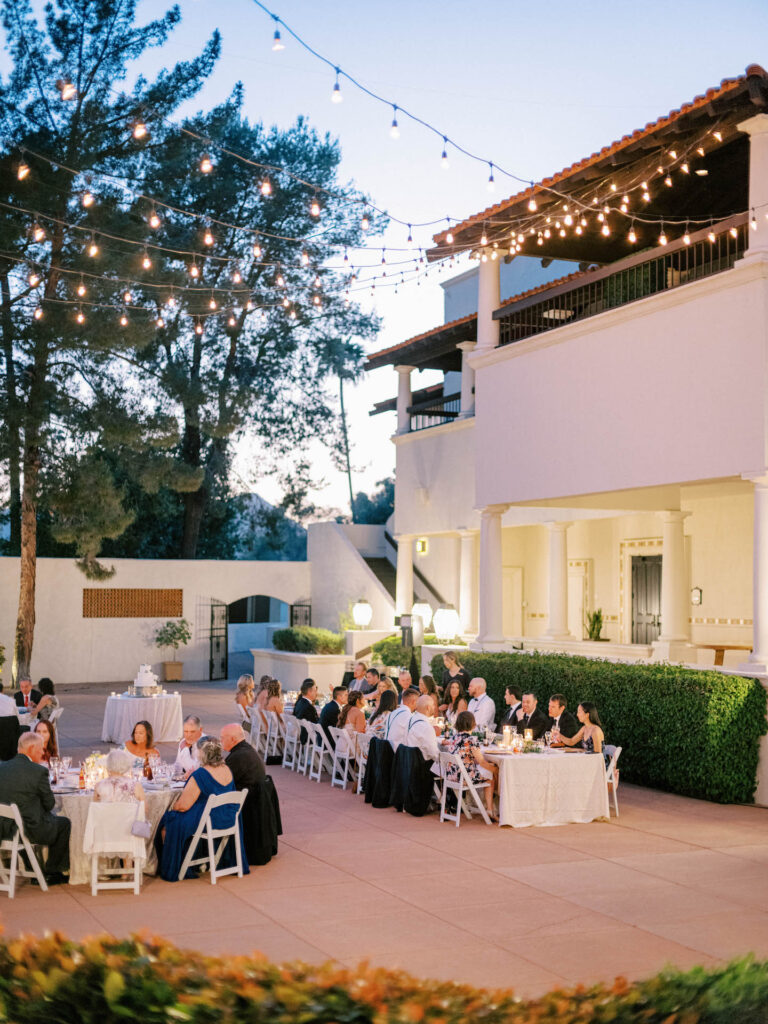 Outdoor wedding reception with long table and round tables at Scottsdale Resort.