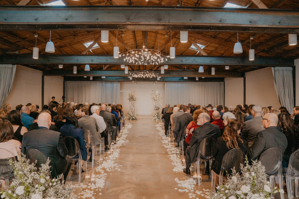 The Clayton House wedding ceremony with back of aisle ground floral, aisle rose pedals, and altar space floral columns.