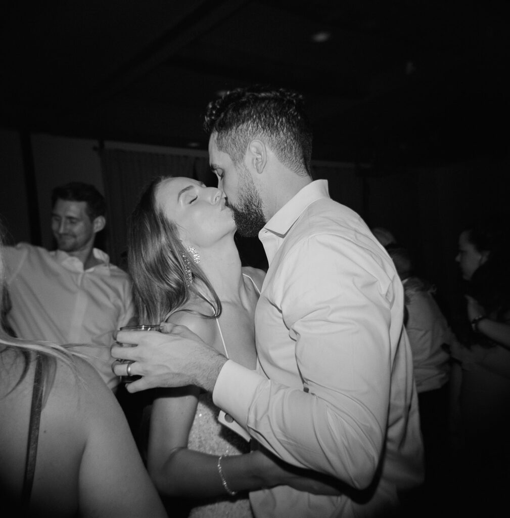 Bride and groom kissing at wedding reception dance.