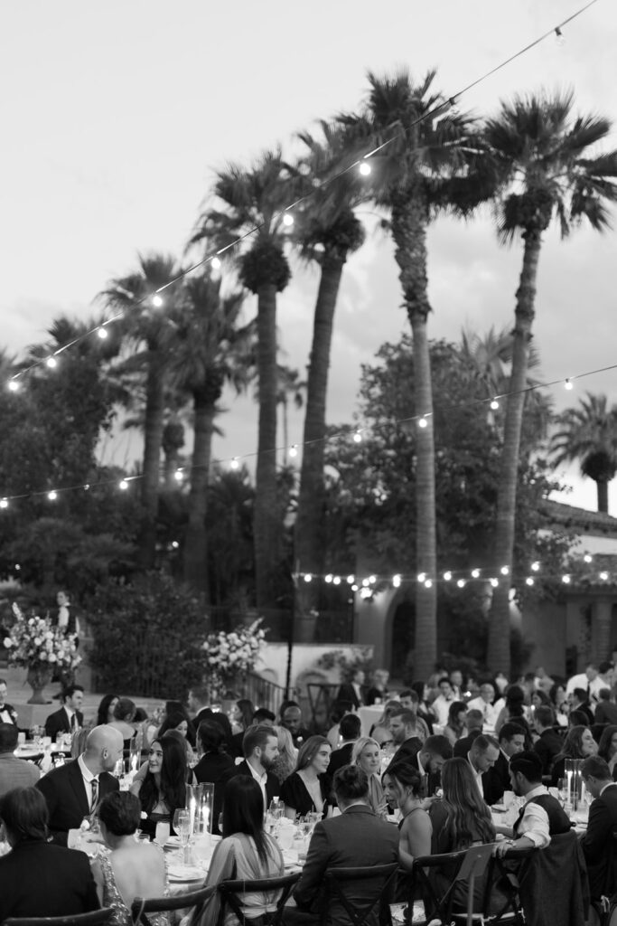 Outdoor wedding reception at Royal Palms with guests at long rectangle tables.