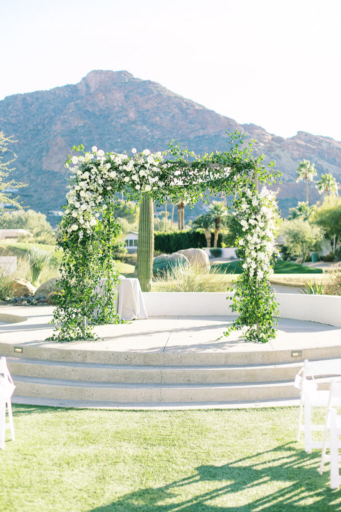 Floral installation on wedding ceremony arch of white flowers and greenery at Mountain Shadows.