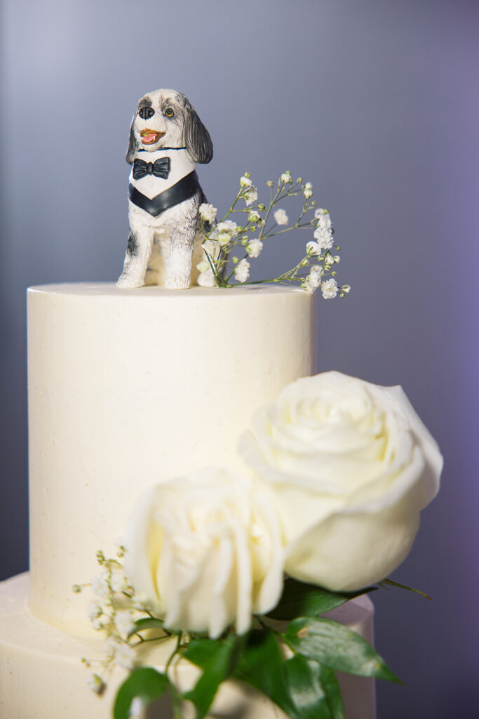 Wedding cake topper of dog with bow tie.