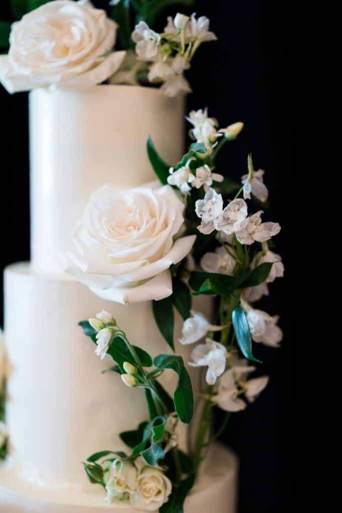 White wedding cake with white flowers added.