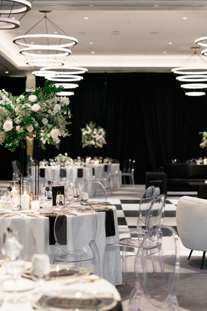 Indoor wedding reception at Royal Palms with dance floor, table centerpieces and white and black colors.