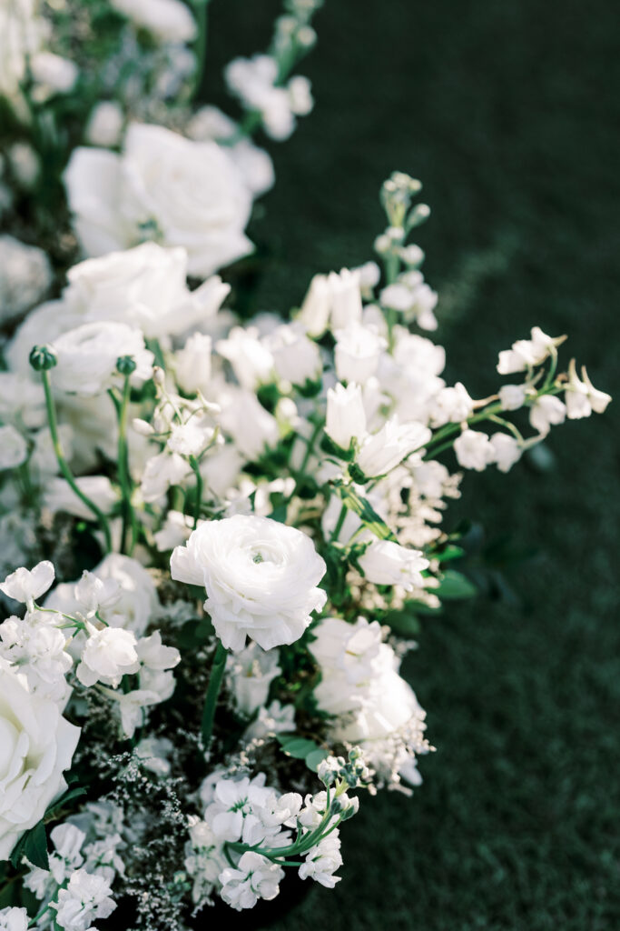 Detail image of white flowers in wedding floral arrangement.