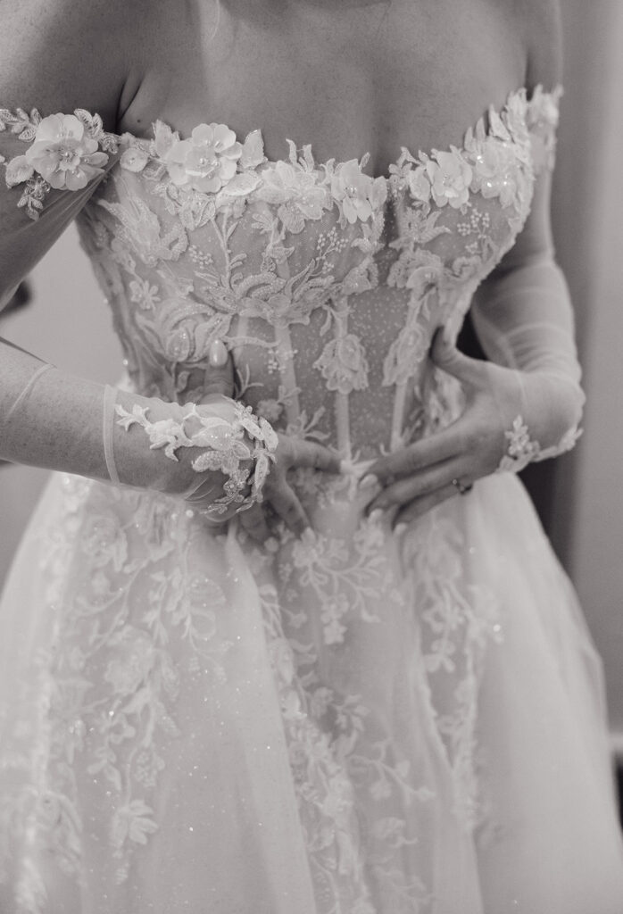Details of gown bride is wearing with sheer parts and applique flowers.