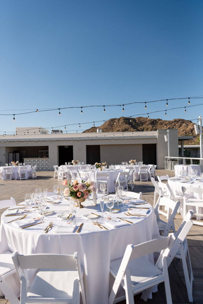 Outdoor wedding reception space at Mountain Shadows with white round tables and flower centerpieces.