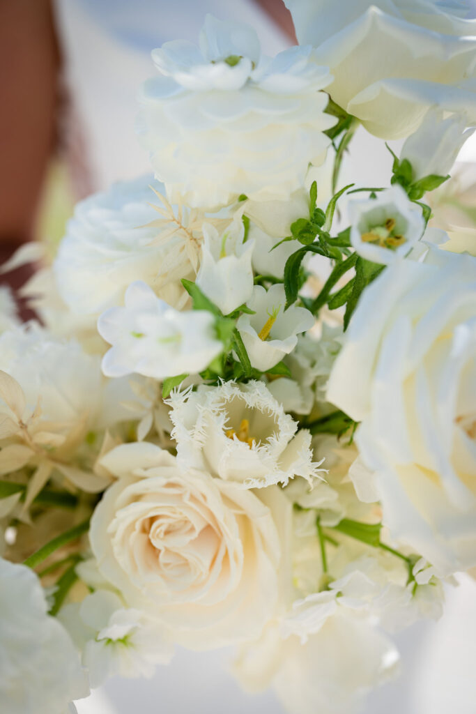 Details of white flowers bridal bouquet filled with roses, frilled tulips.