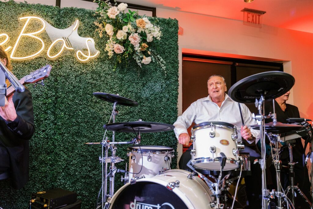 Father of the groom playing drums with the live band. 