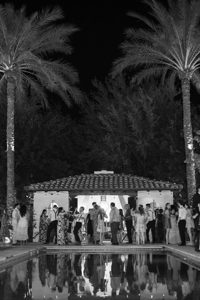 Evening wedding reception outdoors around pool.