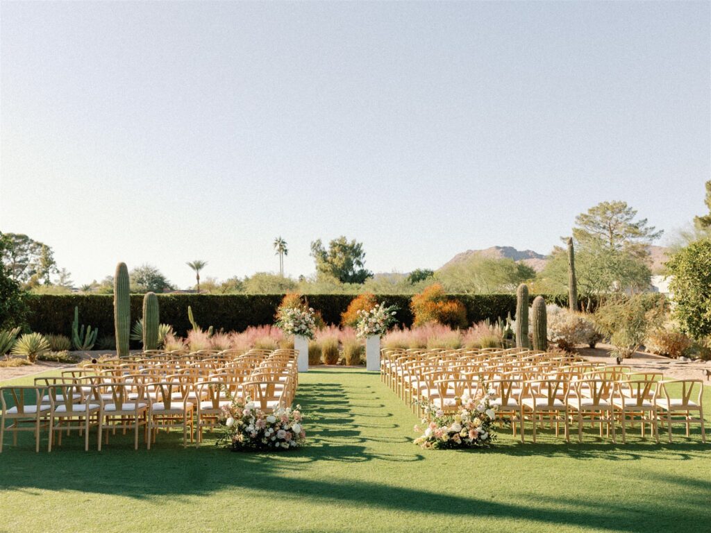 Outdoor wedding ceremony with back of aisle floral arrangements at Andaz resort.