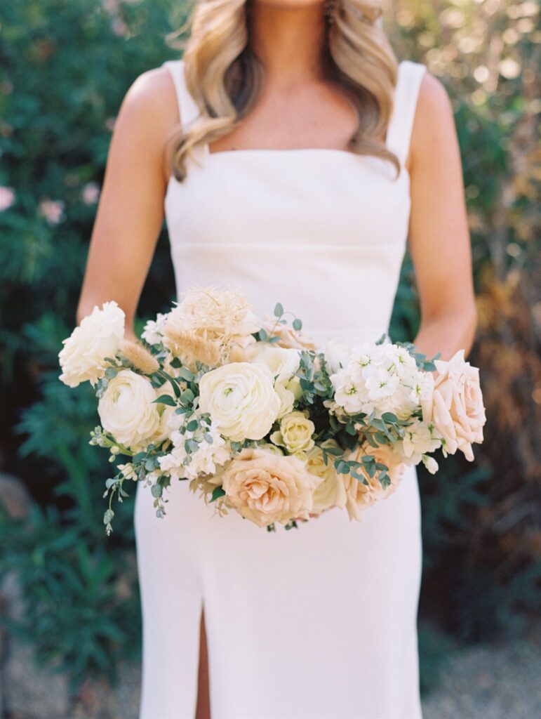 Bridal bouquet of white, blush, and soft tan floral, including dried floral elements.