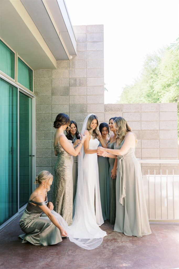 Bride getting ready with bridesmaids on patio.