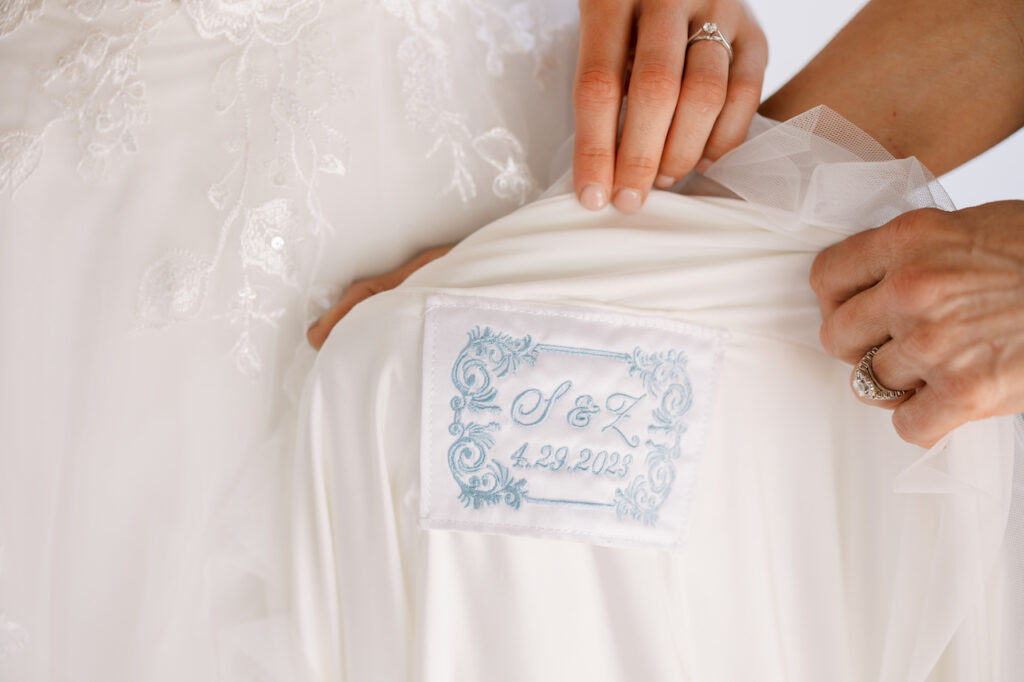 Blue embroidery details of initial and date on wedding gown.