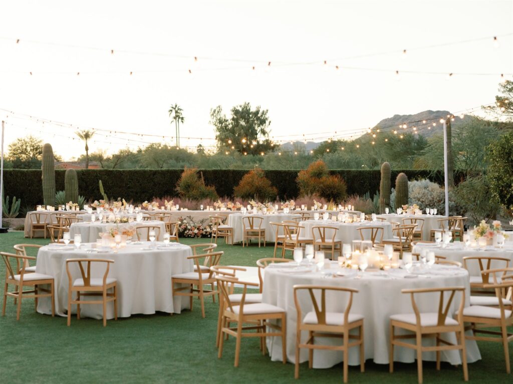 Outdoor wedding reception at Andaz resort with round tables and long head table, floral centerpieces and ground floral.