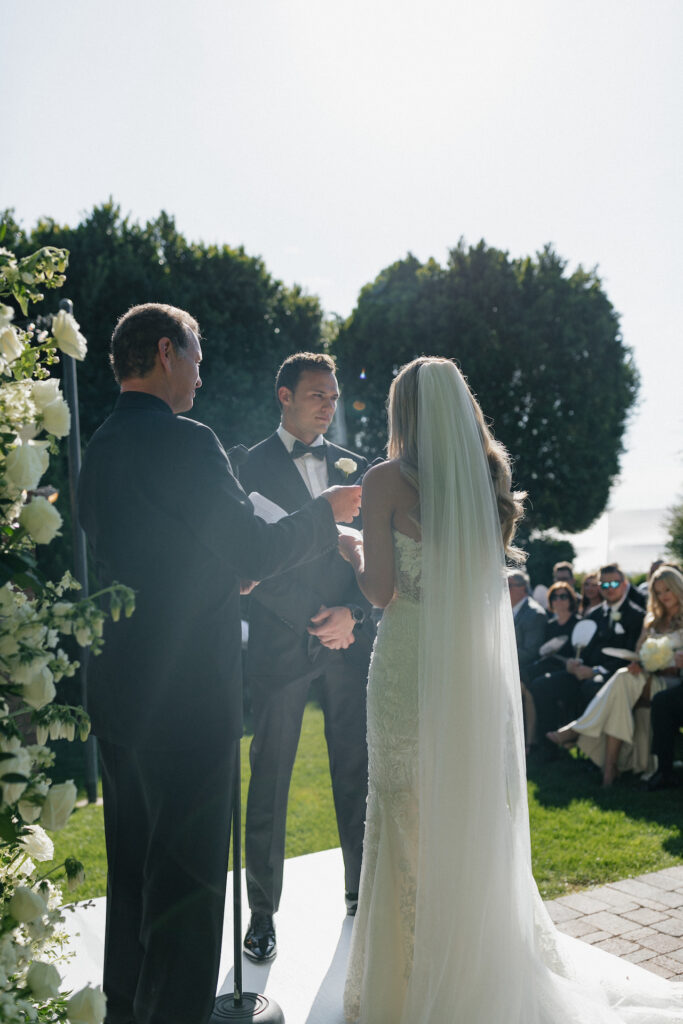 Bride and groom exchanging vows standing in outdoor wedding altar space.