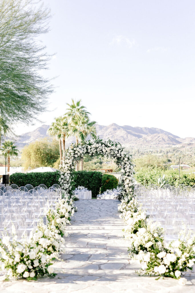 Outdoor wedding ceremony at Sanctuary resort decorated with white wedding flowers.