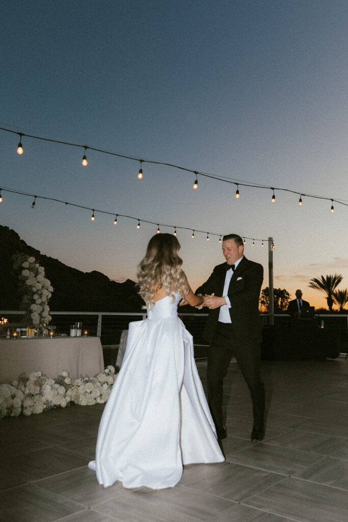 Bride and groom dancing at wedding outdoor patio reception.