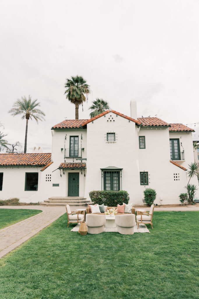 The Coronado House venue with staged lounge seating in front grass.