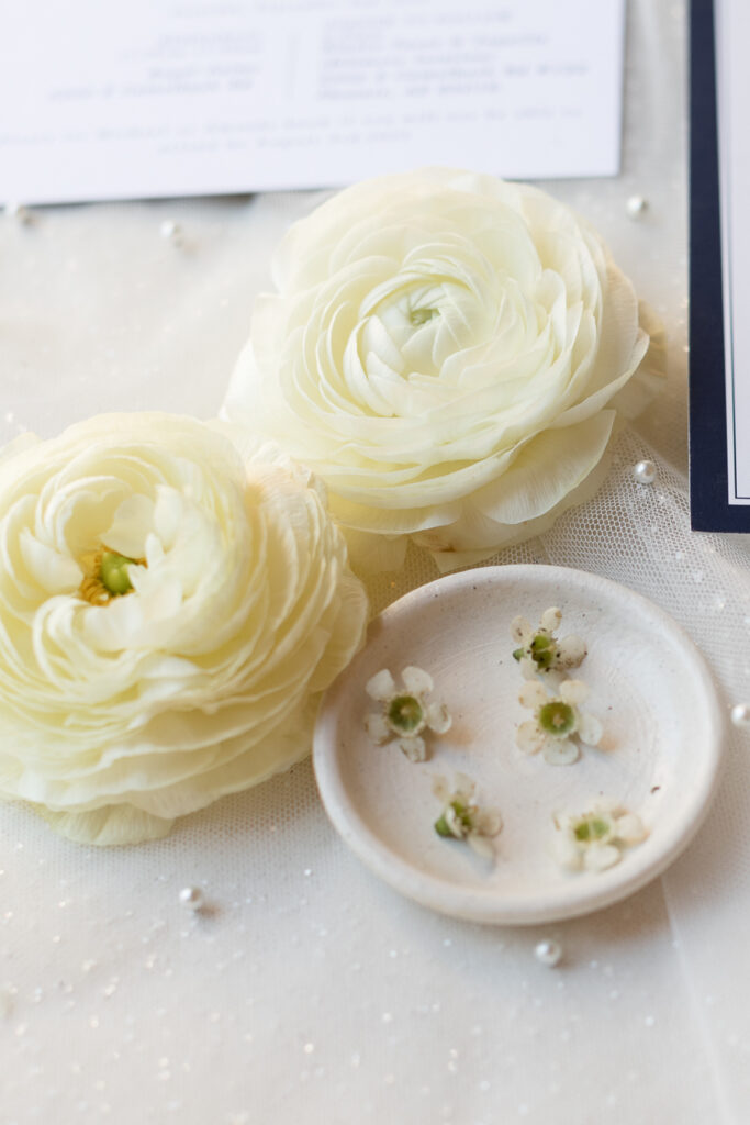 Wedding details with white ranunculus flowers.