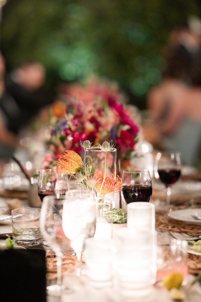 Long reception table centerpieces of floral and candles down center.