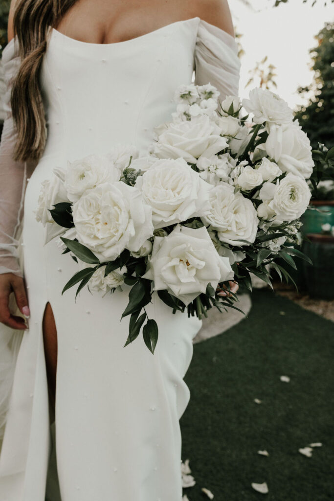 Lush bridal bouquet of white floral and greenery, with large white roses, ranunculus.