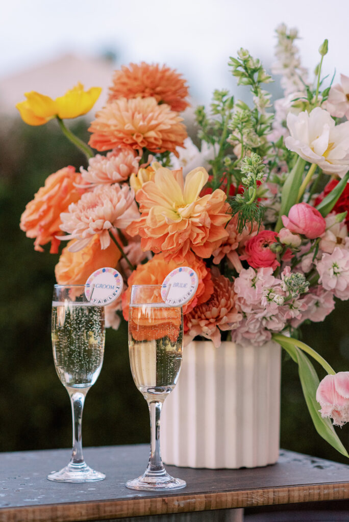 Wedding bar arrangement in bright spring colors of orange, pink, yellow, and white.