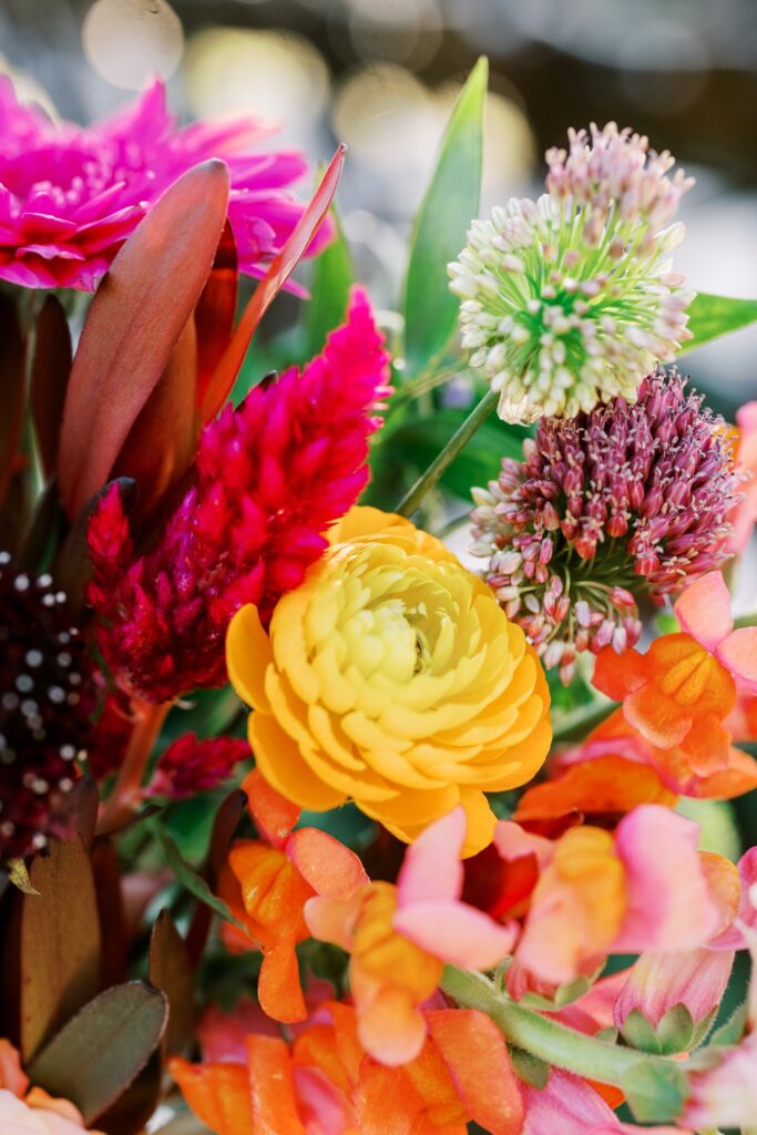 Detail image of wedding flowers in orange, pink, and fuchsia.