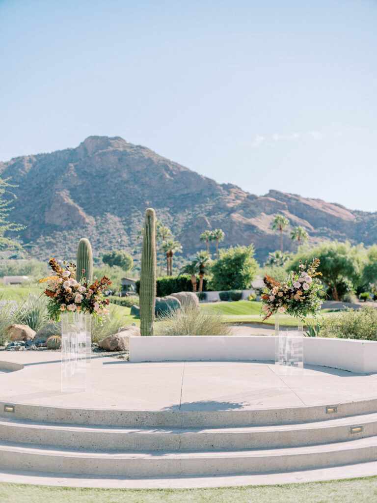 Wedding ceremony space with two clear acrylic columns with floral arrangements sitting on top.