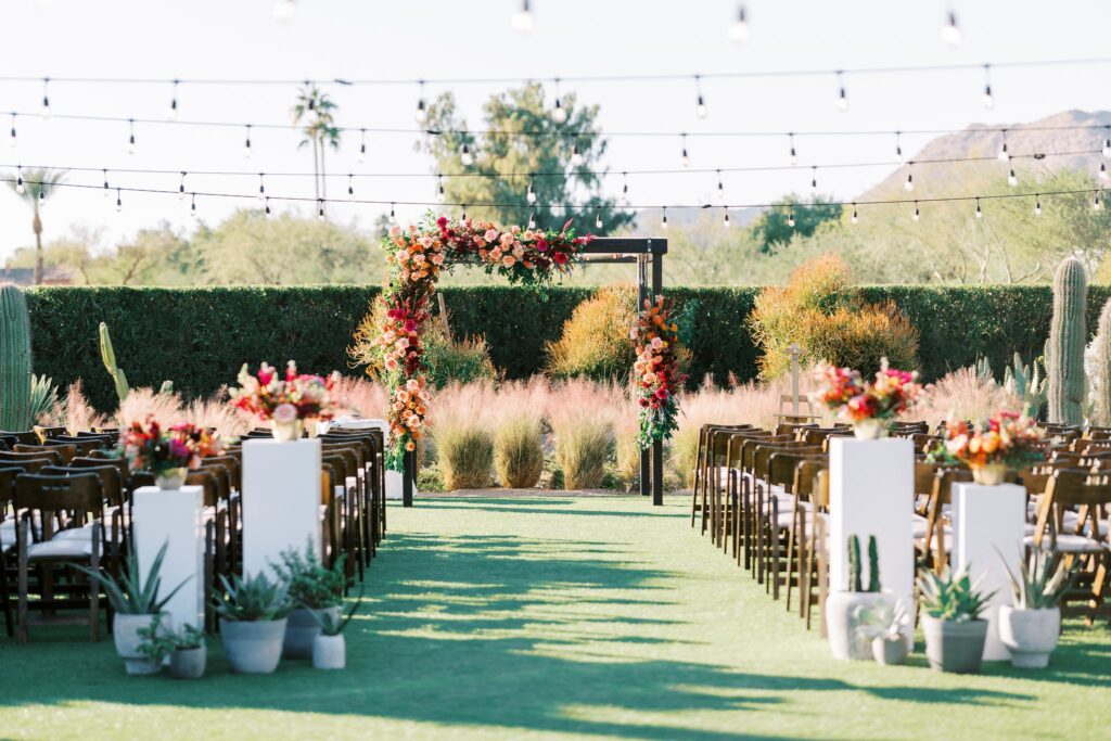 Wedding ceremony flowers in back of aisle and on chuppah in altar space.