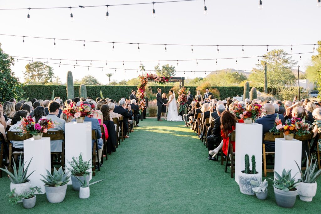 Guests seated during wedding ceremony at Andaz Resort with bride and groom at front altar space.