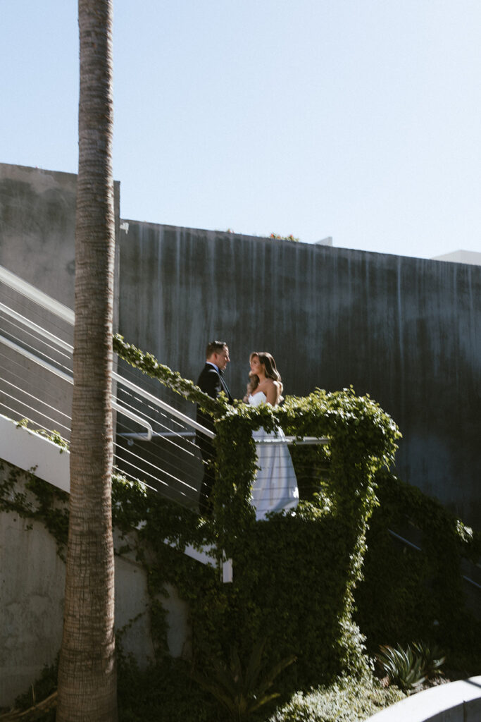 Bride and groom standing on stairs at Mountain Shadows venue, looking at each other.