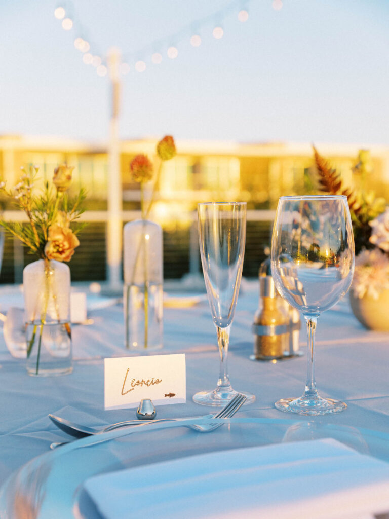 Wedding reception place setting with bud vase decor.