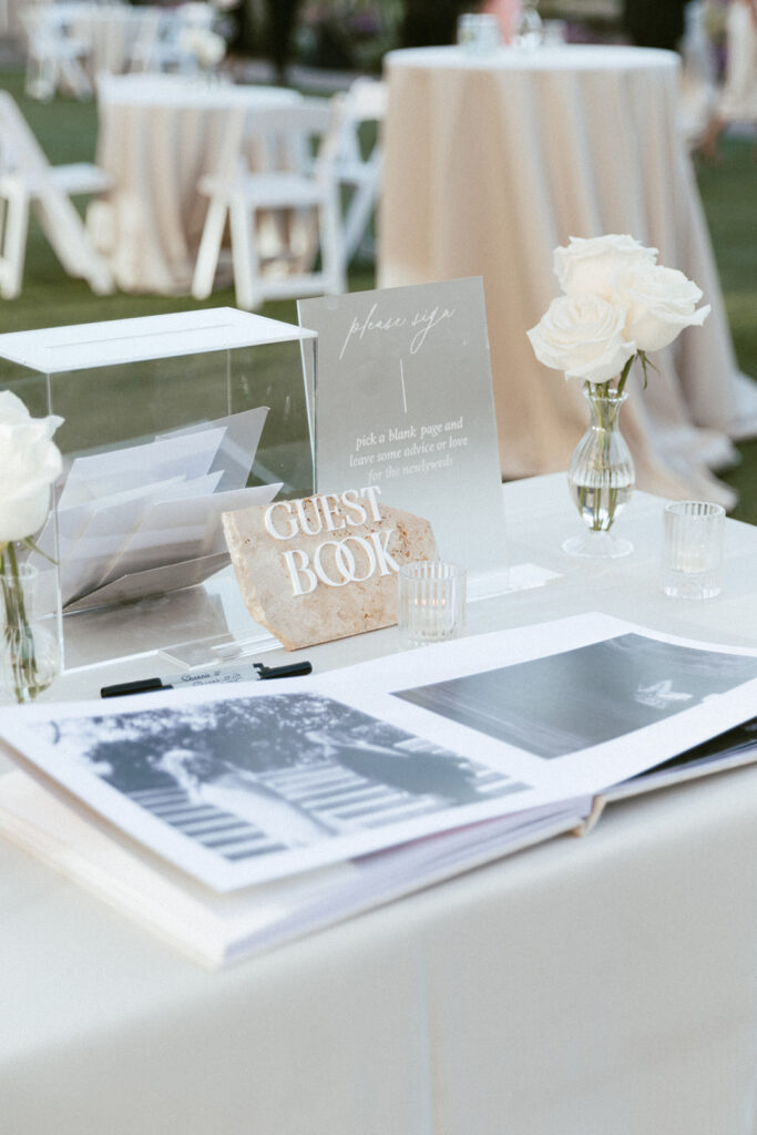 Guest book table with white roses bud vases.