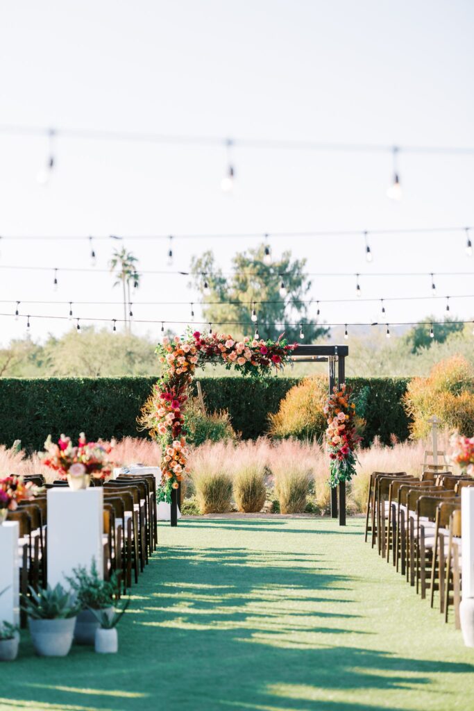 Outdoor wedding ceremony chuppah decorated with wedding flower installations.