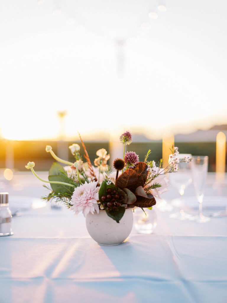 Wedding reception centerpiece of deep burgundy, pink, and white floral.
