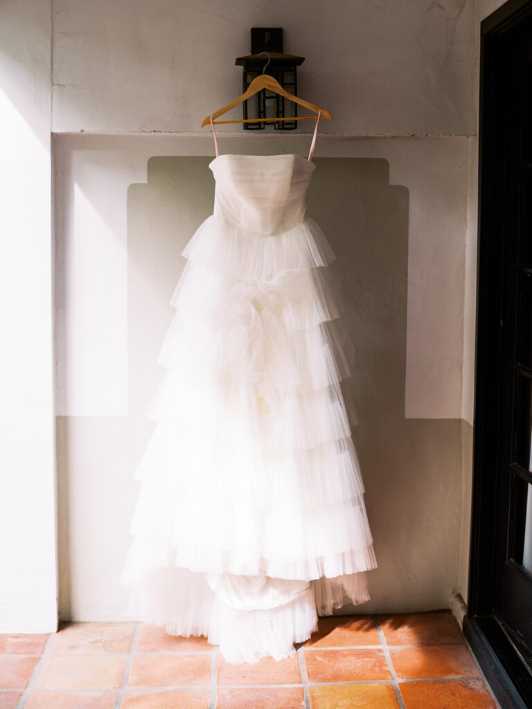 Wedding gown hung from light off wall.