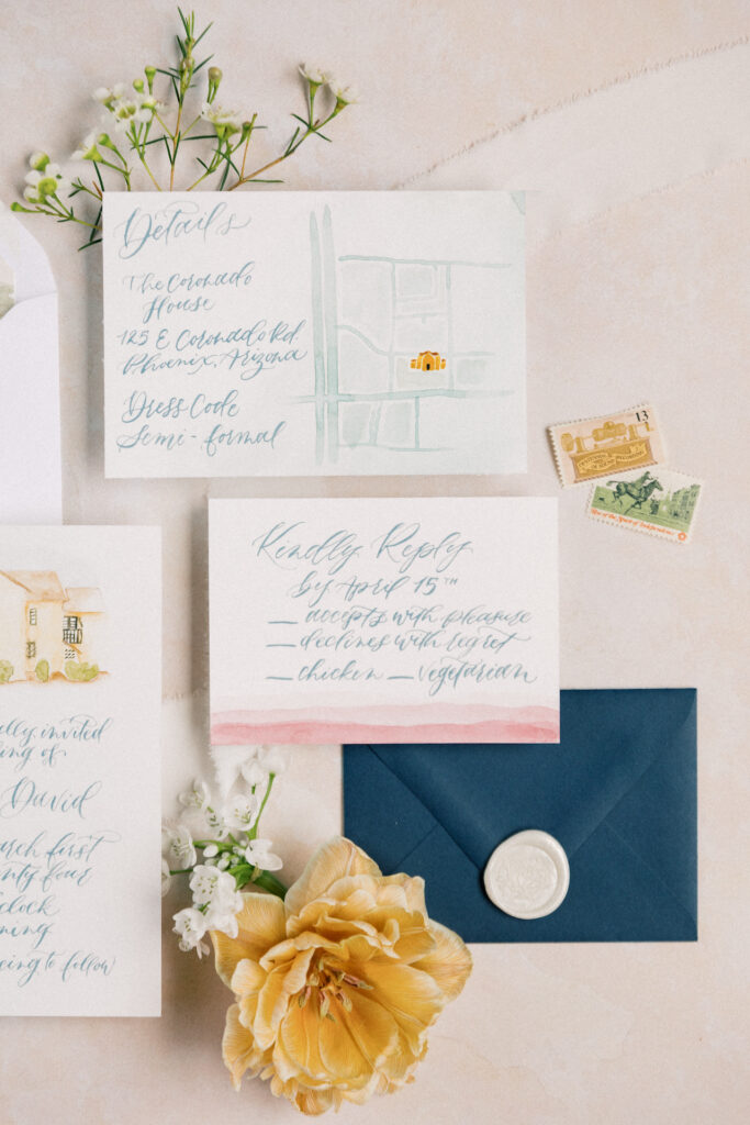 Invitation flat lay of pink, yellow, and navy blue.