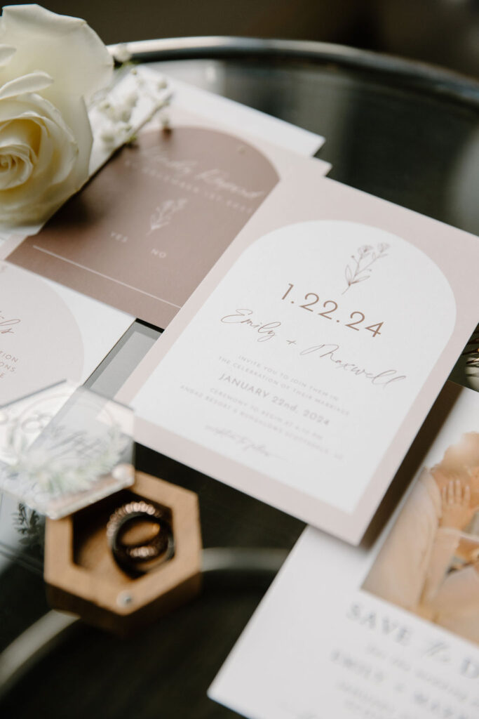 Wedding invitation flat lay of taupe, tan and white colors.