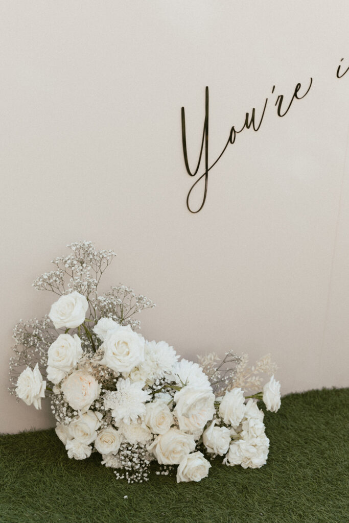 Ground flower arrangement of white roses and mums with baby's breath.