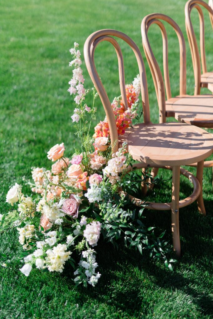 Wedding back of aisle ground floral at ceremony aisle entrance in white, pink, and peach colors.