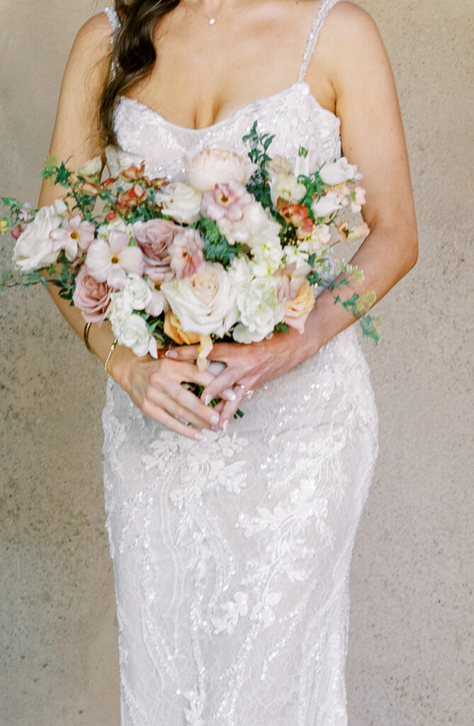 Bride holding bouquet of white and pink flowers.