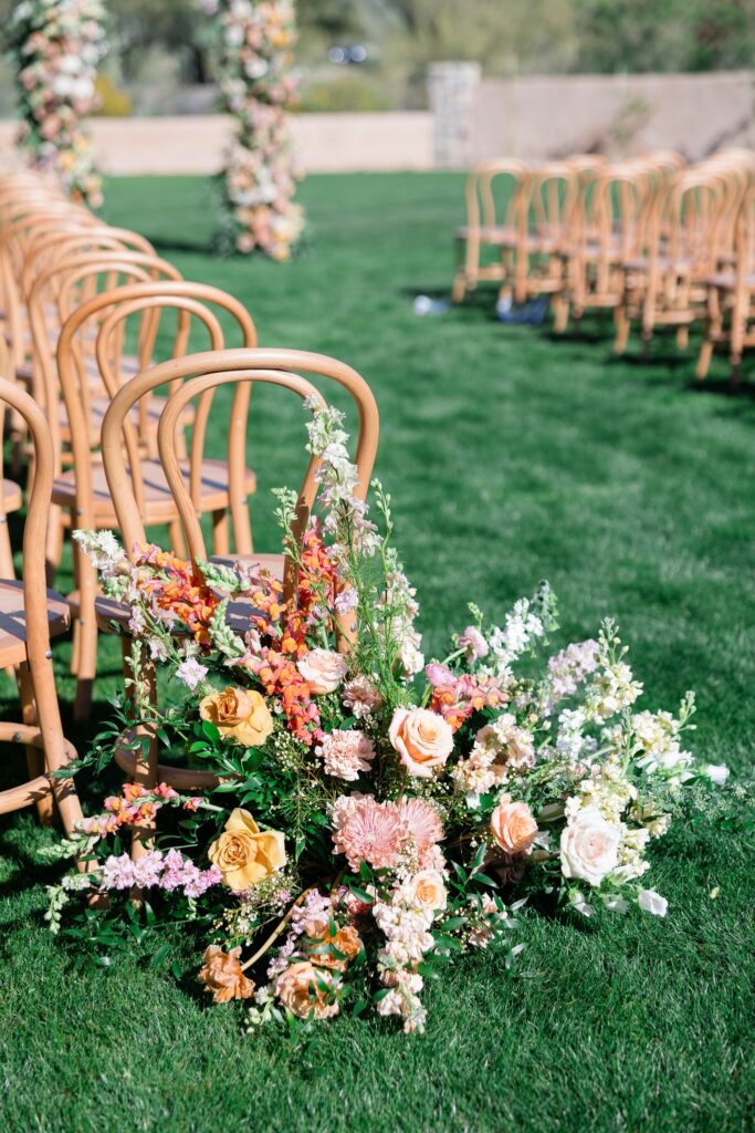 Wedding back of aisle ground floral at ceremony aisle entrance in white, pink, and peach colors.