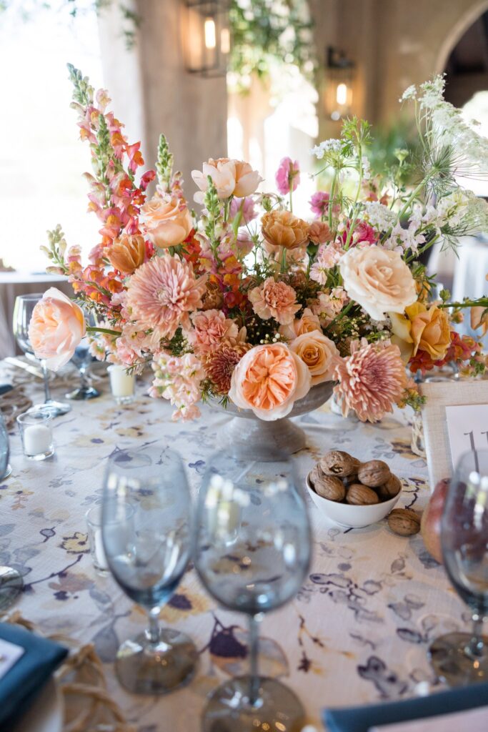 Wedding flowers in gold, pink, and peach colors in reception centerpiece.