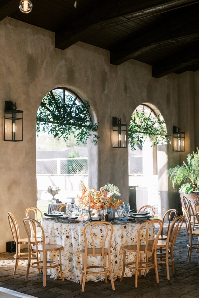 Wedding reception round table with pattern linens and flower centerpiece.