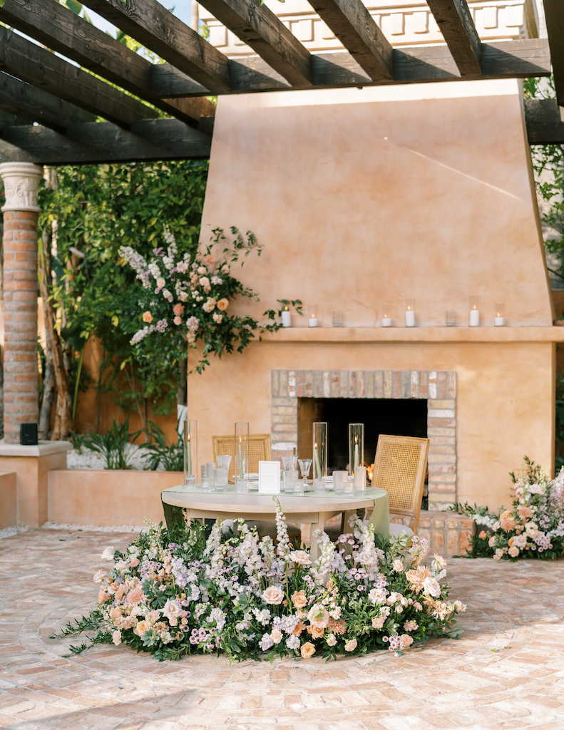 Ground floral at reception around sweetheart table in front of fireplace at Royal Palms.