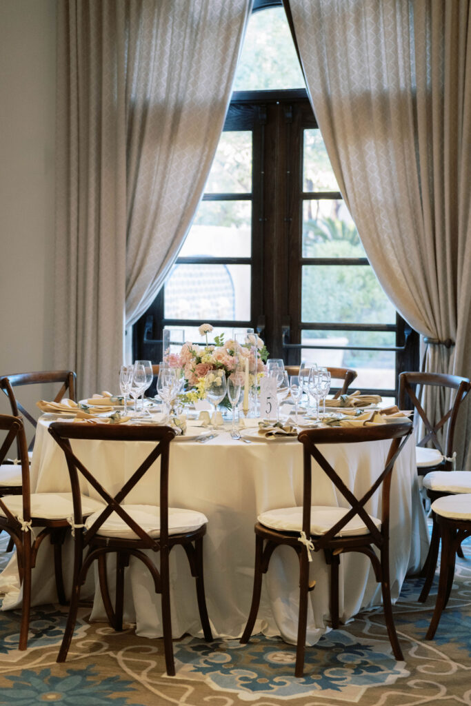 Royal Palms indoor wedding reception round table with place settings and floral centerpiece.