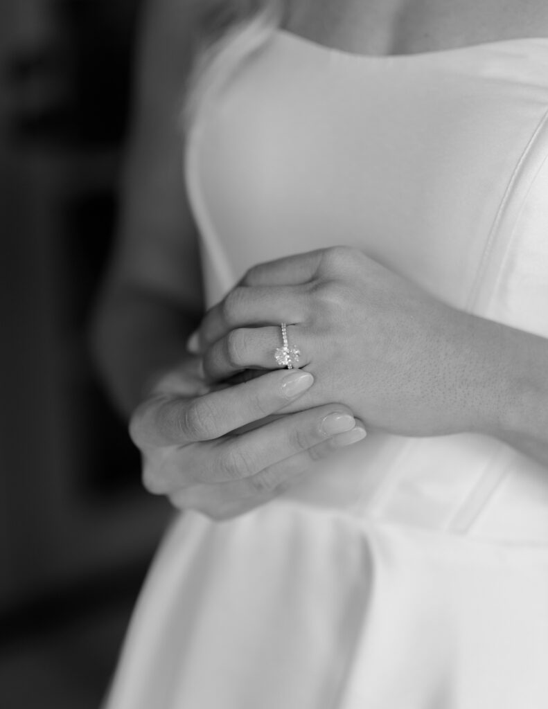 Details of bride's ring on her finger, other hand's finger gently toughing it.